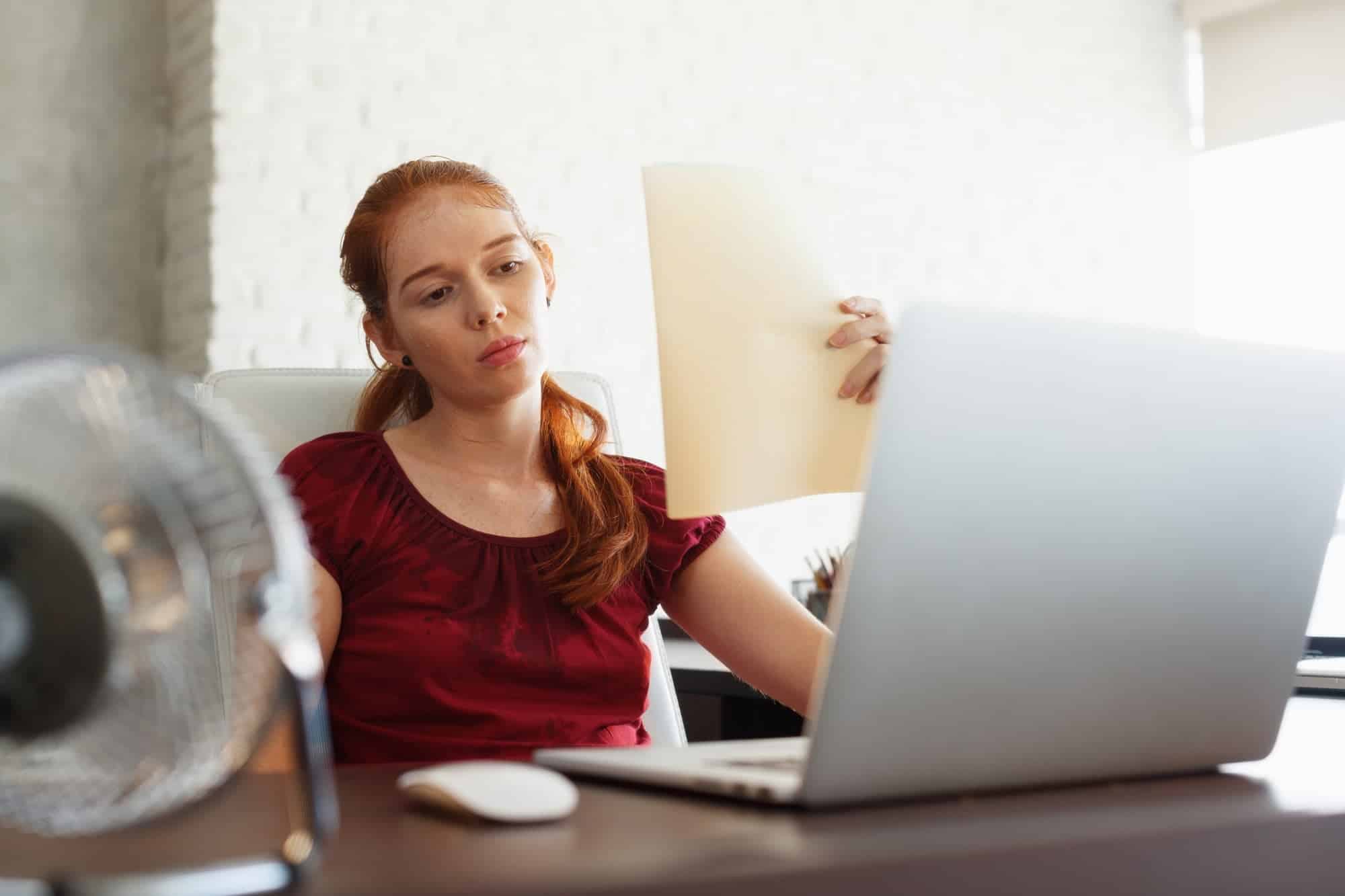 Businesswoman Sweating At Work With Broken Conditioner